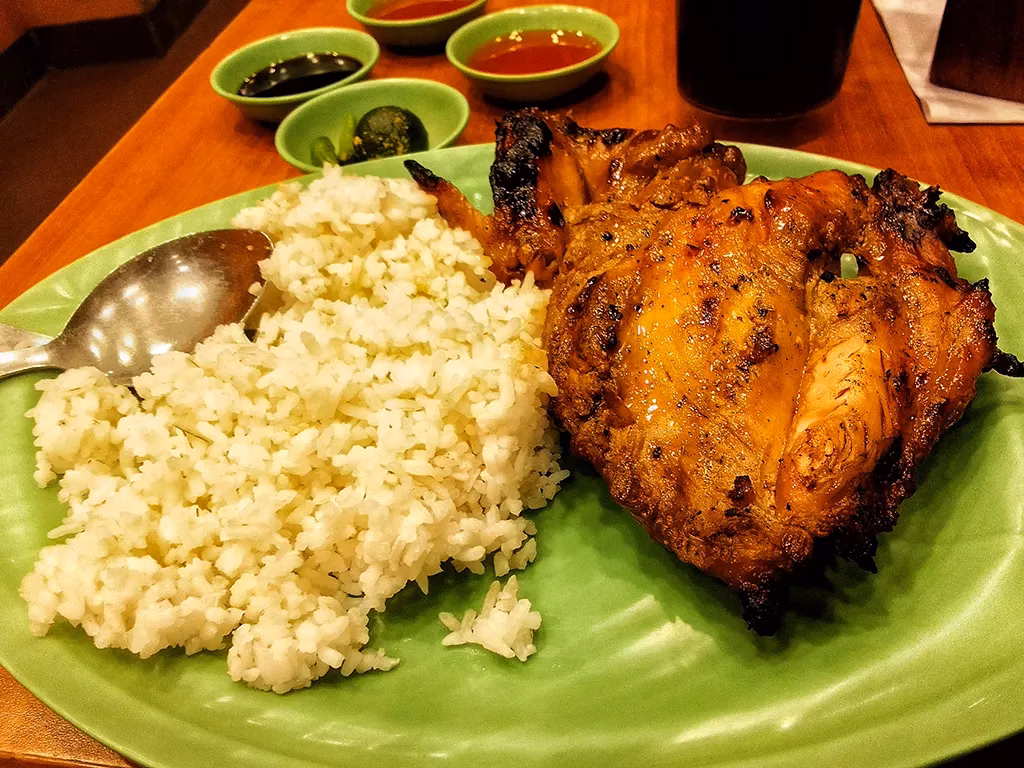 Negros' chicken inasal is typically served with garlic rice, calamansi, and soy sauce on a banana leaf.
