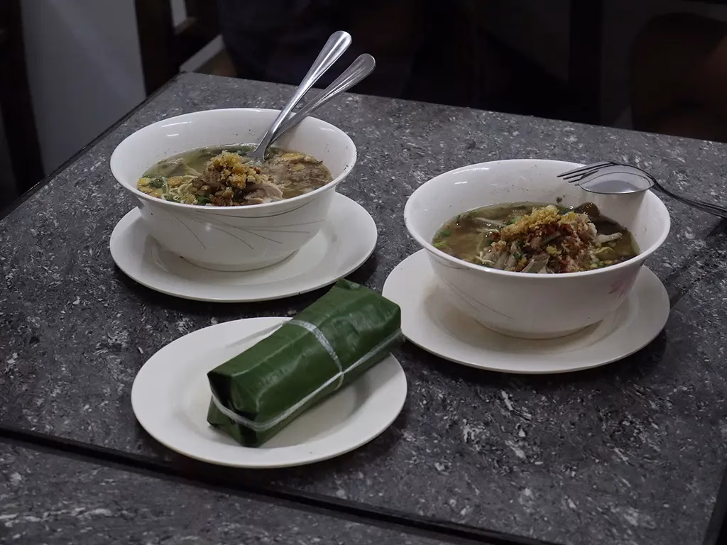 Now we have a picture of Two bowls of La Paz batchoy with a puto, served in La Paz Public Market. This is a very common dish in the Iloilo region-sort of a comfort food.