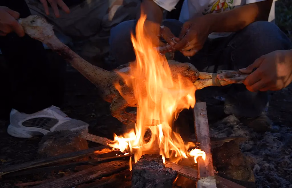 This is a Pinikpikan is a chicken or duck dish from the mountains of the Cordillera region in the Philippines. It is being cooked the old-fashioned way by first singing off all the feathers over a open flame.