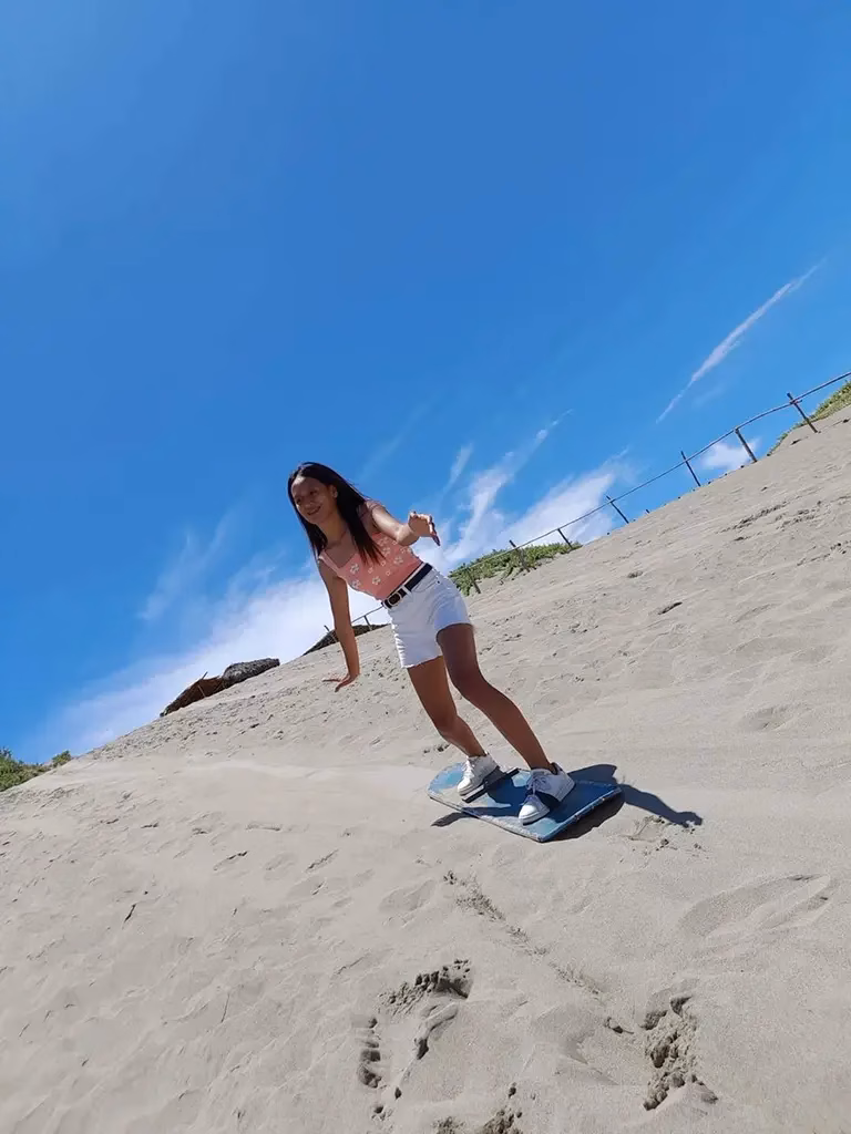 A picture of a young lady sandboarding in Paoay, Philippines.