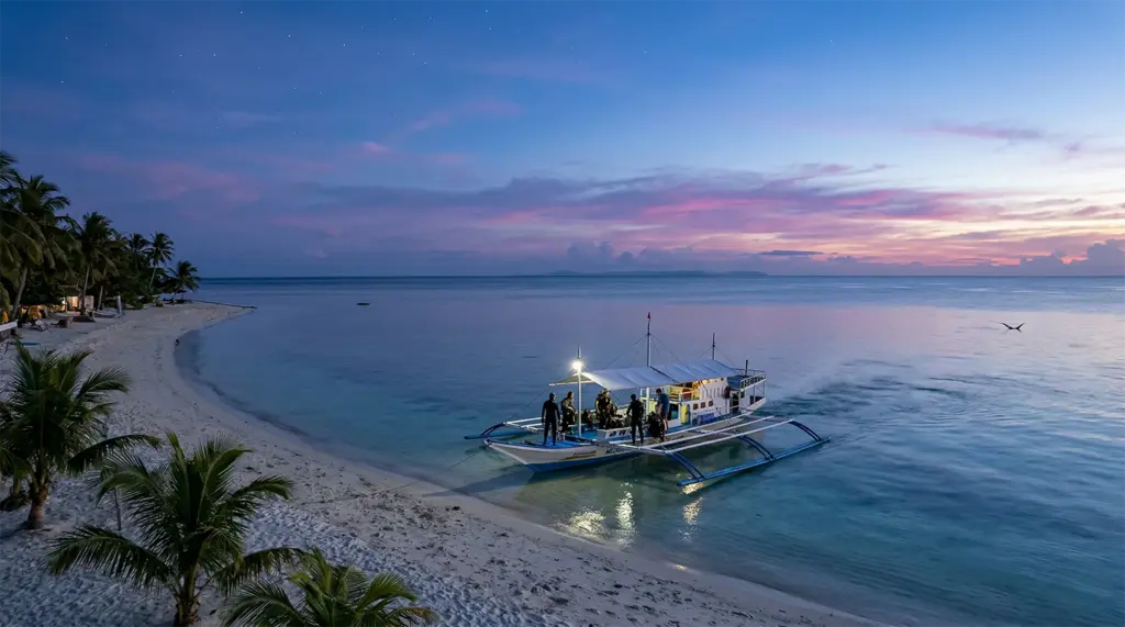 Dive boat departing Malapascua Island beach before sunrise for Monad Shoal thresher shark dive, Cebu
